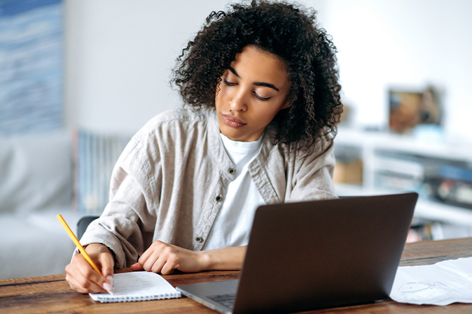 Young woman writing in her notebook