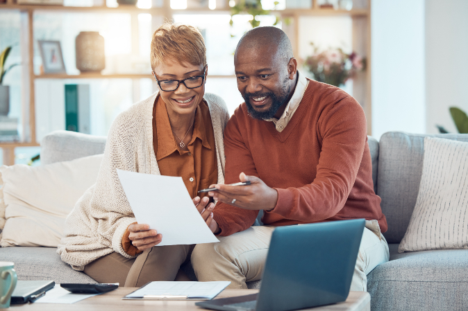 Happy couple on sofa checking document