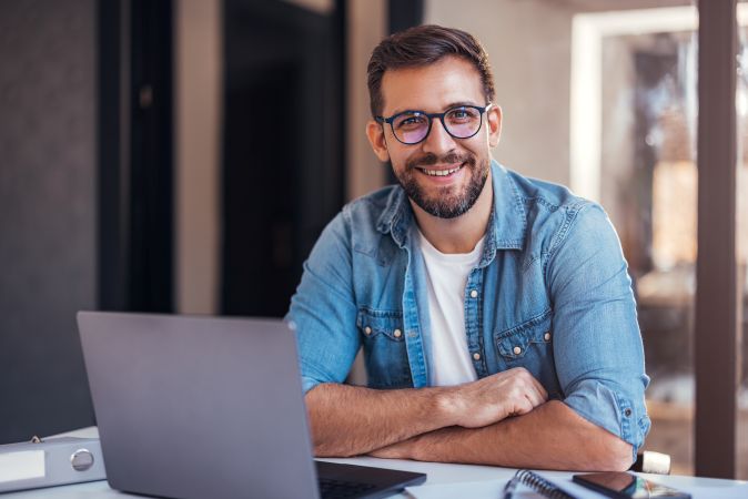 Portrait of smiling man sitting in office and looking at camera.