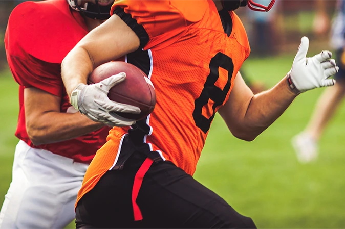 Football player carrying a football down the field