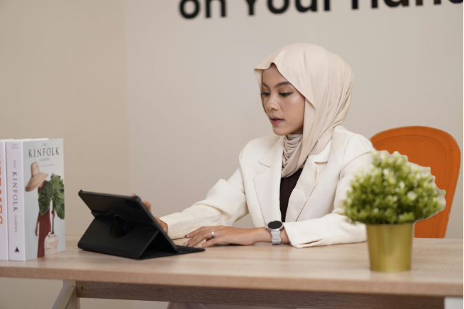 professional woman sitting at desk using a tablet