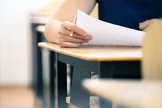 Student writing exam in classroom