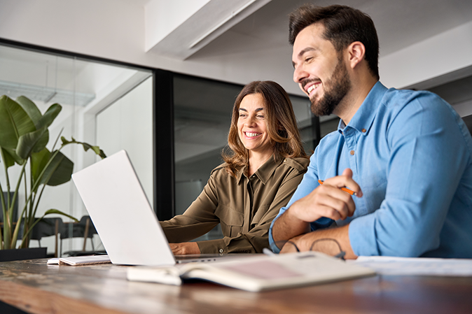 Professional woman training male associate on computer