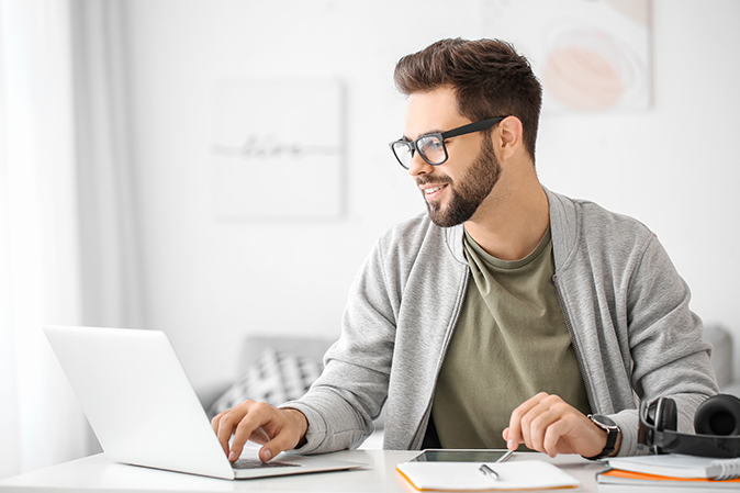 Young man using laptop for online learning at home