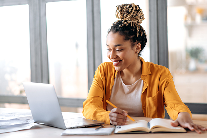 young woman attending online classes on her laptop