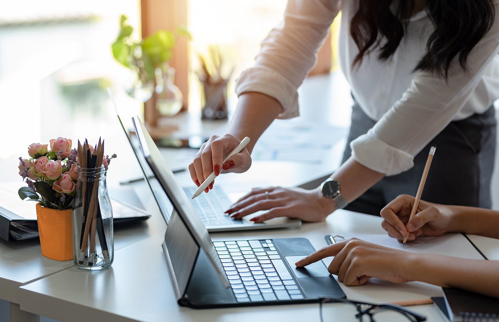 Two people working together in an office on a couple of laptops