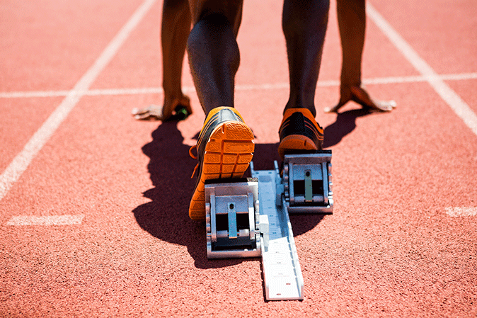 Man with feet set on starting blocks on a track for a race