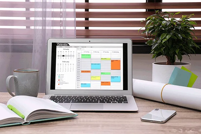 Laptop sitting ona desk showing a calendar on it