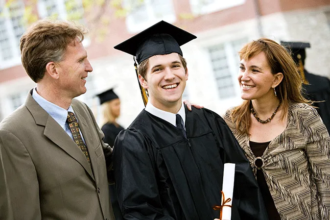 Young man graduate standing outside with his parents