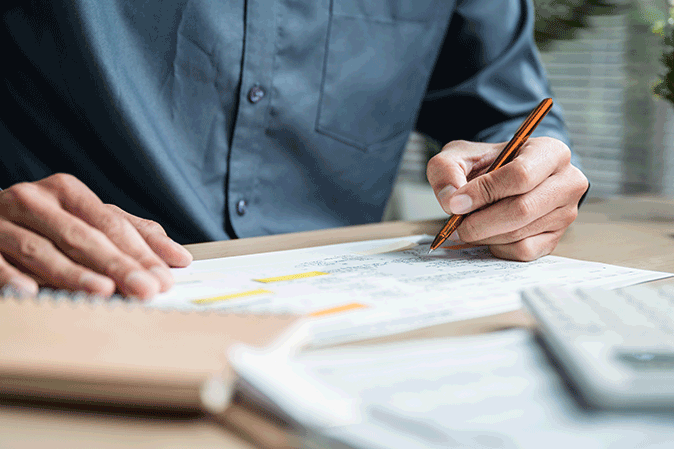 Man writing notes on paper at his desk