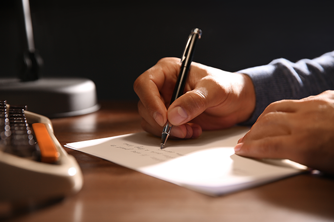 Man writing a letter with a pen