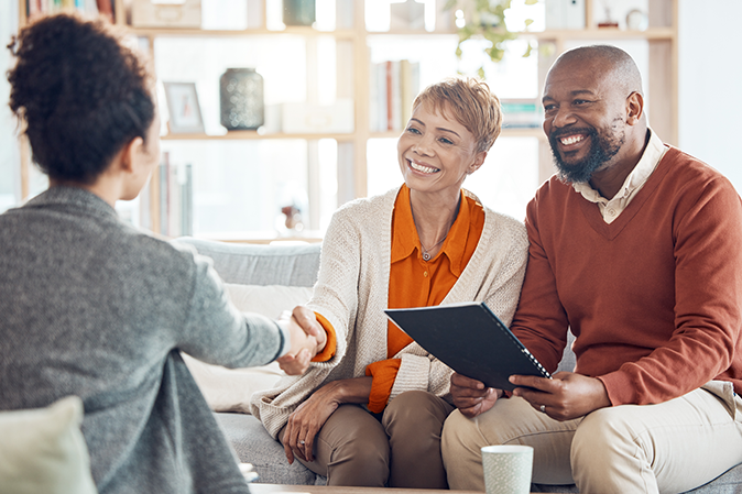 Young woman shaking hands with an elderly couple about their estate planning