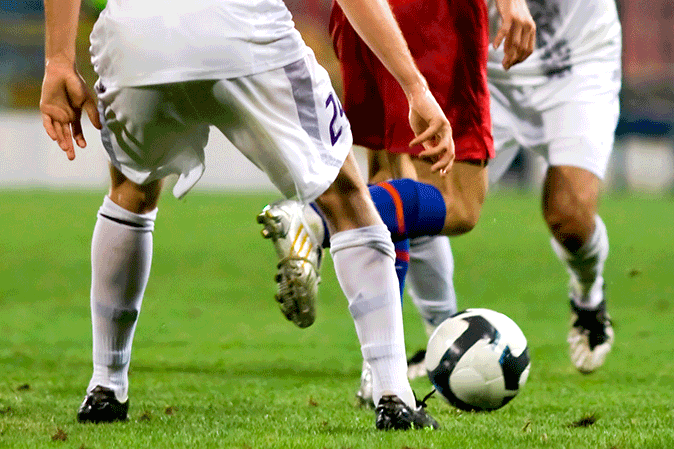 Soccer players fighting over a ball in a game