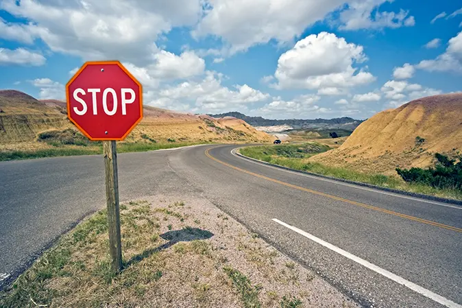 Stop sign at the middle of a rural intersection
