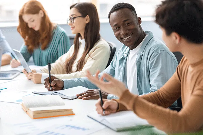 Students sitting in a row working on writing assignments
