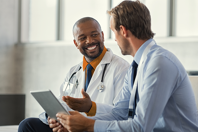 Two male doctors discussing a case on a tablet