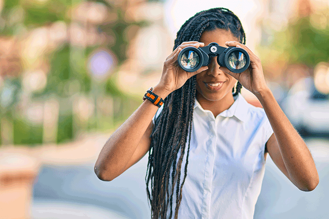 Woman looking through a pair of binoculars