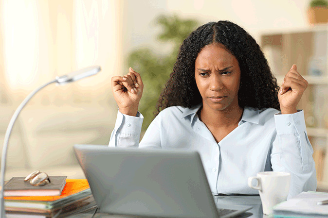 Young woman looking confused at her laptop