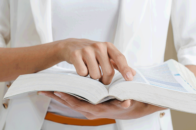 Women looking up a word in a dictionary