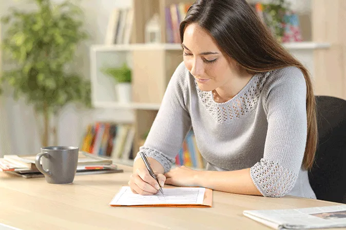 Young woman sitting at a desk filling out an application