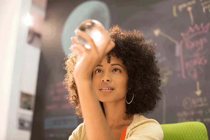 Young woman looking through a crystal ball she is holding