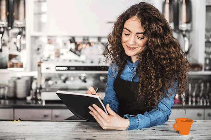 Young woman studying while working in a cafe