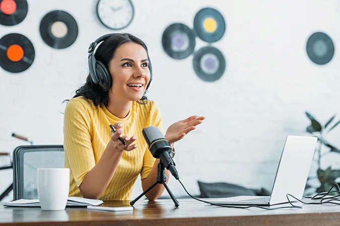Young woman talking into a microphone for a podcast