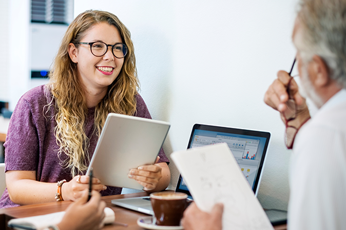 Young woman college student holding a tablet meeting with her advisor