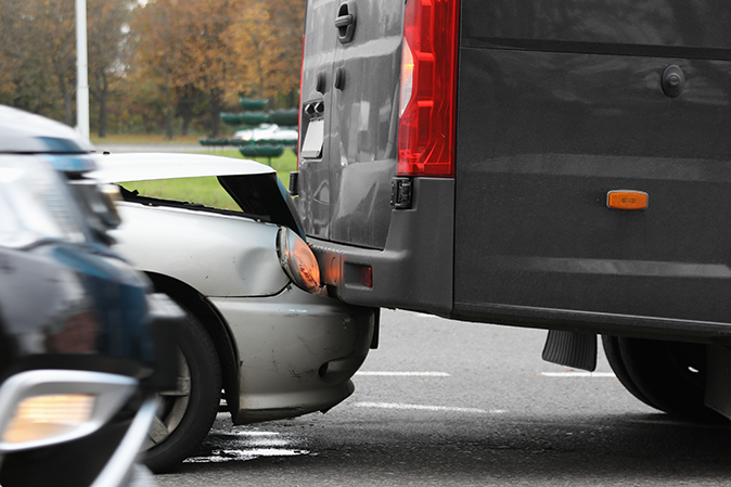 Fender bender on a street between a silver car and a black pickup truck