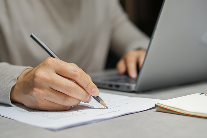 Man taking a test while typing on a laptop