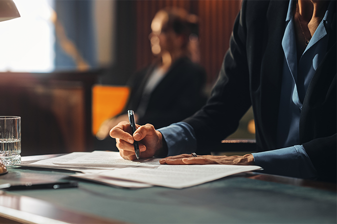 Woman lawyer is writing on documents in a courtroom
