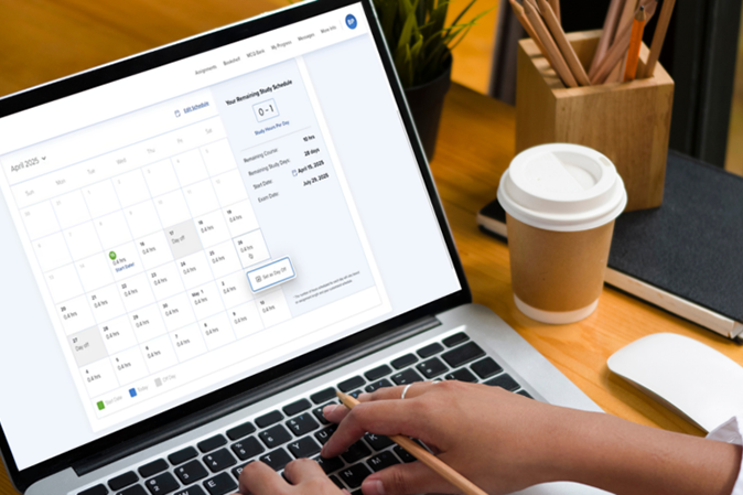Woman sitting at a desk setting up her customizable calendar on laptop