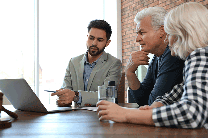 Young male lawyer with a laptop meeting with an older couple