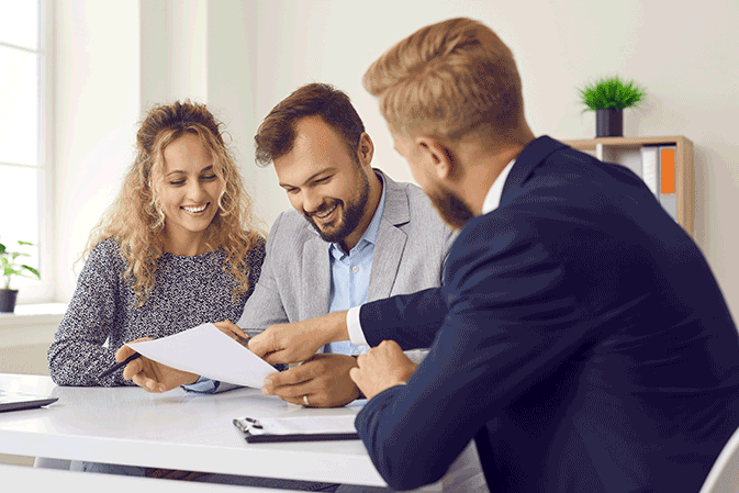 Young male lawyer meeting with a couple in an office about paperwork