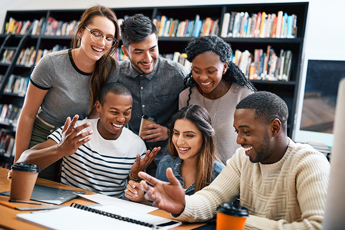Group of multi-racial college students studying together in a library
