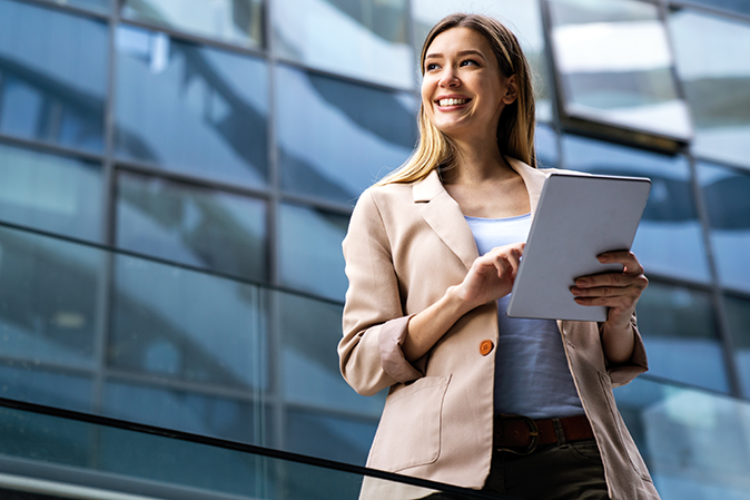 Young woman professional outside with a tablet smiling