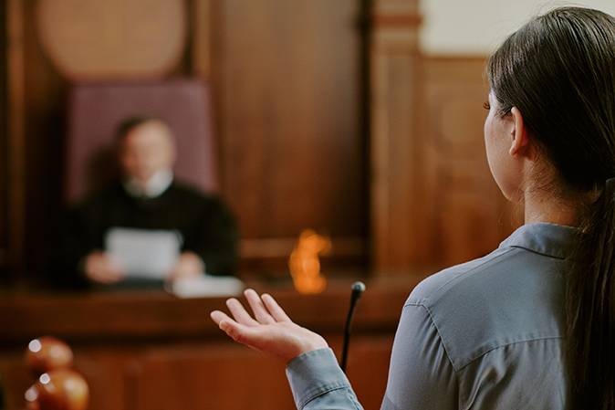Young woman speaking before a judge in a courtroom