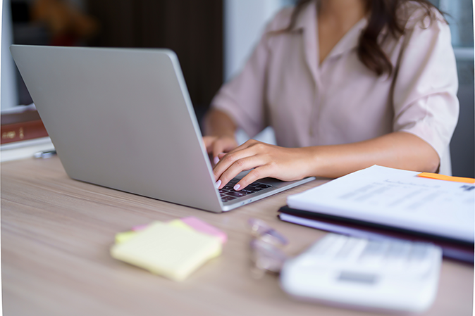 Young woman typing a writing assignment on a laptop