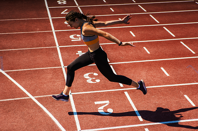 Young woman winning the race on the track
