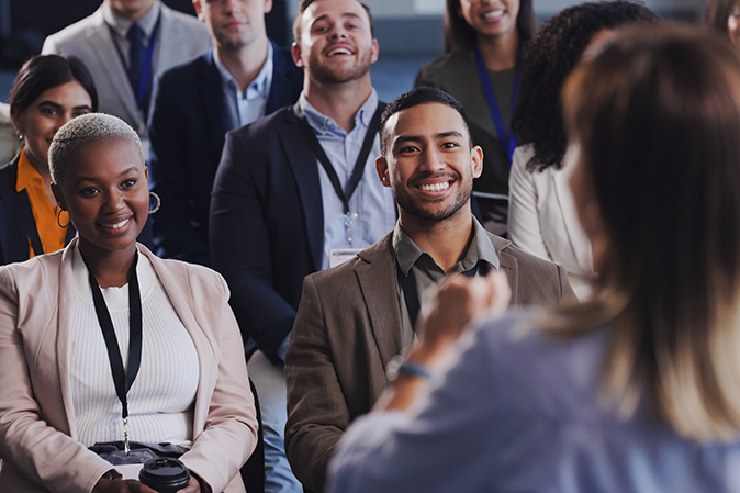 Group of professionals sitting in a room listening to a speaker