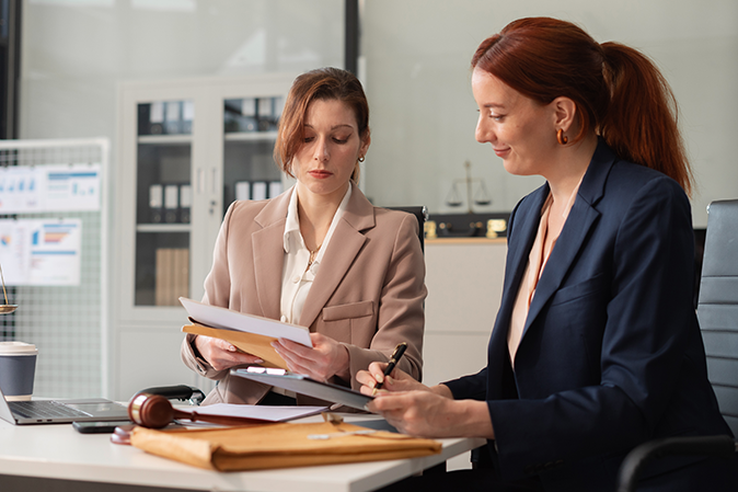 Two professional women going over documents in an office