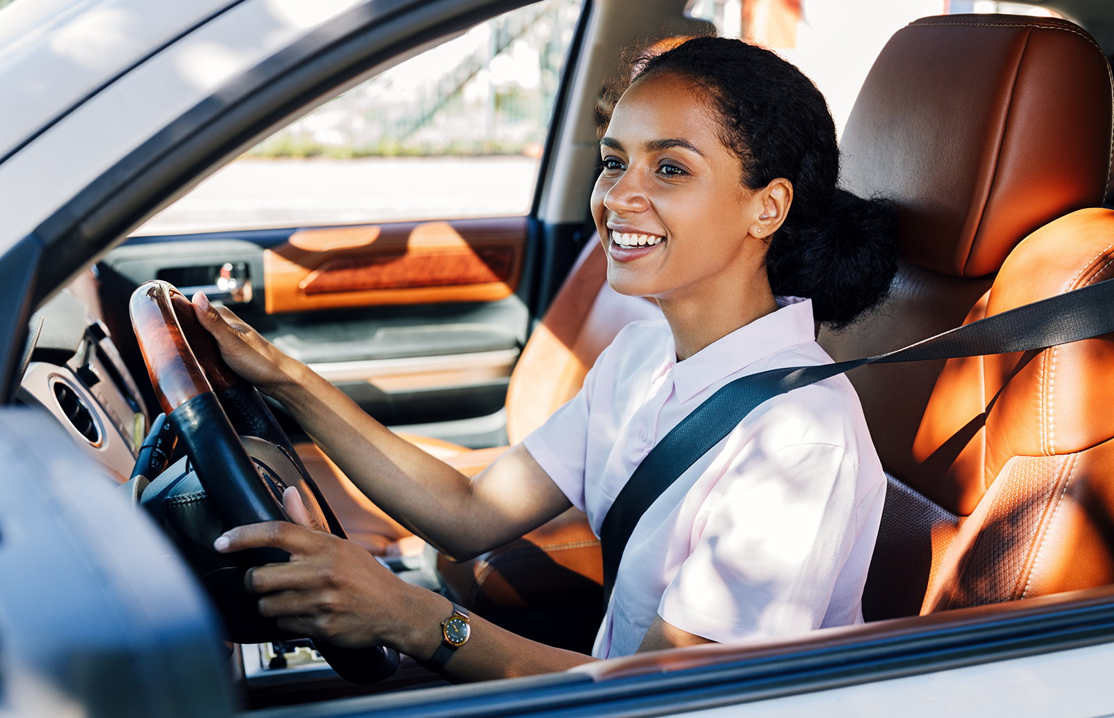 Young woman smiling while driving a car
