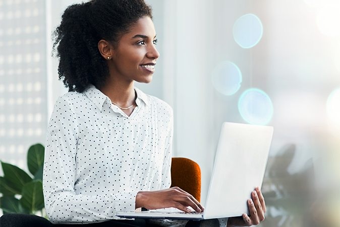 African American woman in white blouse using a laptop