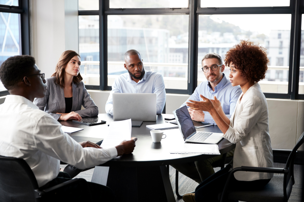 A female lawyer addressing a group of people around a boardroom table