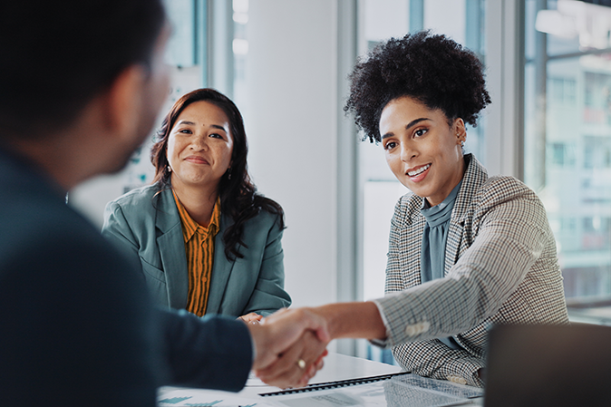 Woman shaking a man's hand at a job interview