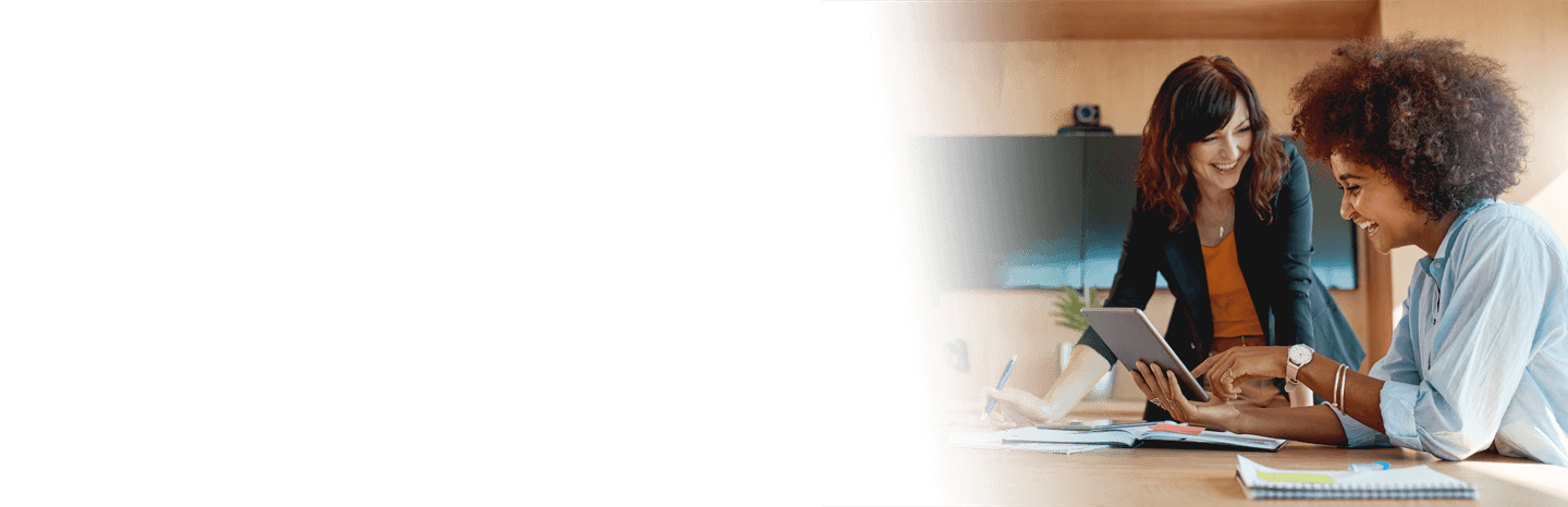 Two professional women in an office working together on a tablet