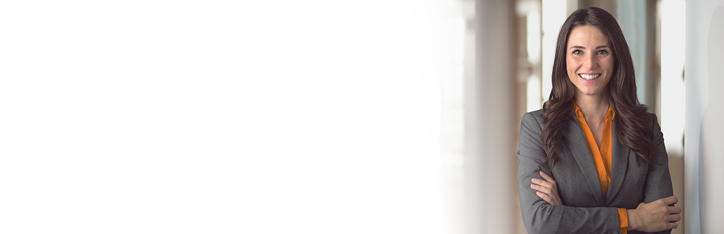 Young woman smiling with arms crossed dressed in a business suit