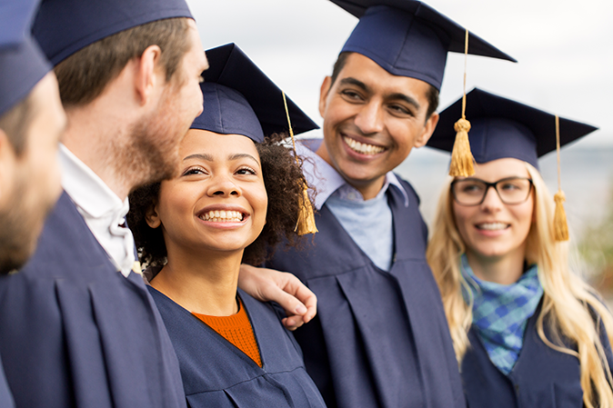 Group of smiling young university graduates