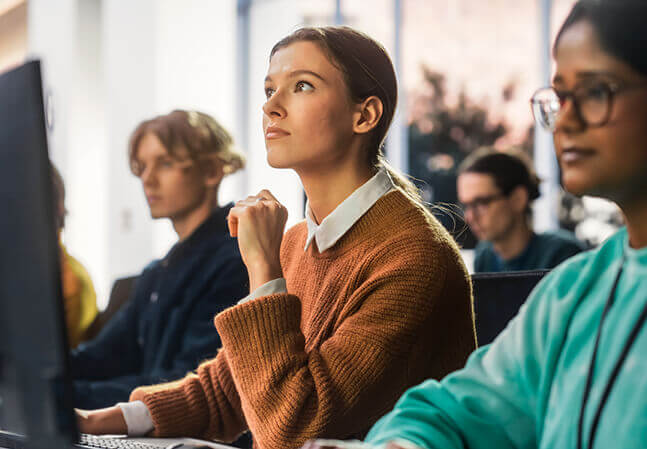 Young woman sitting in a class in front of a computer