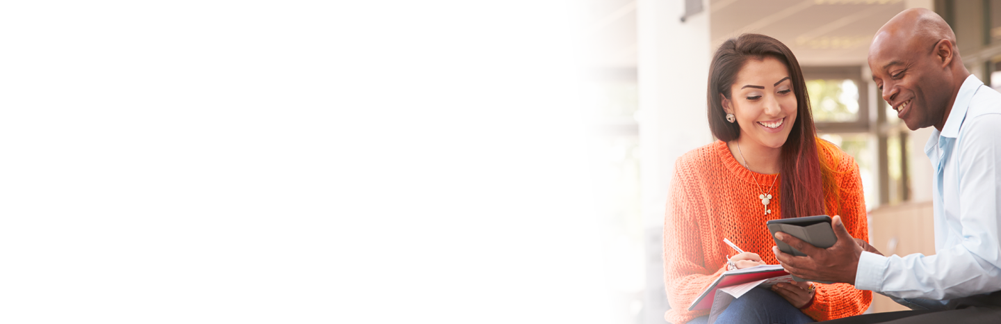 Senior man holding a tablet working with a student who is taking notes